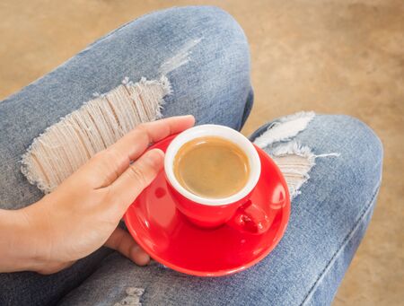 Woman in torn jeans sitting at coffee shop, stock photoの写真素材