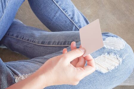 Woman in torn jeans sitting on the ground, stock photo