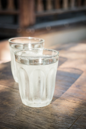 Double glasses of cold water on wooden tableの写真素材