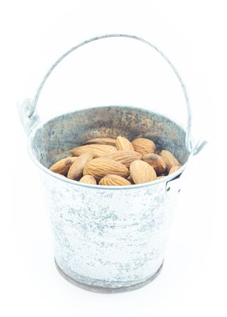 Almonds in bucket isolated on white backgroundの写真素材
