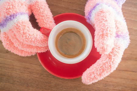 Gloved hands holding cup of coffee, stock photoの写真素材