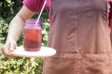 Barista serving iced black coffee with vintage filter effect, stock photo