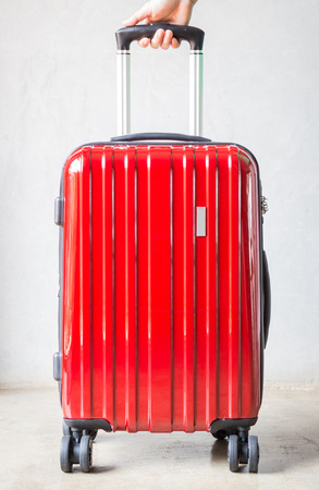 Hand on red travelling suitcase, stock photoの写真素材