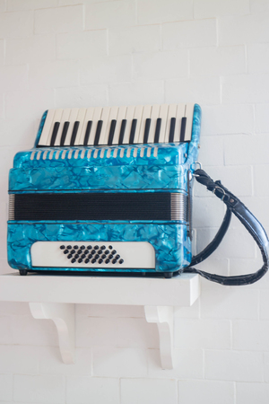 Blue accordion in white room, stock photo