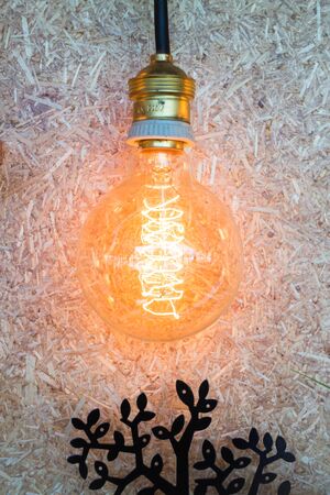Vintage hanging light bulb decorated on brown wall, stock photo