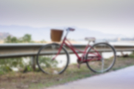 Vintage red bicycle beside river road, stock photoの写真素材