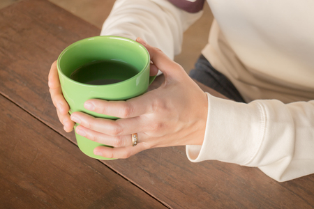 Woman hand on hot green tea drinking, stock photoの写真素材