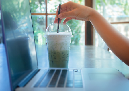 Woman Hand On Iced Milk Green Tea Drink, stock photoの写真素材