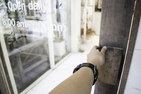 Woman hand opening shop door, stock photoの写真素材