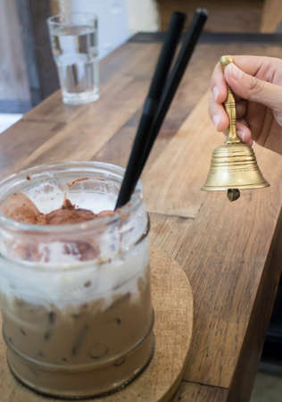 Hand on brass bell in coffee shop, stock photoの写真素材