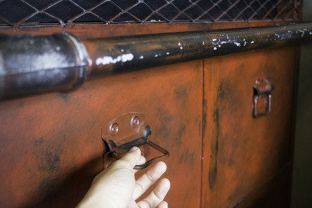 Hand on red metal antique distressed cabinet, stock photo