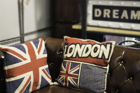 Vintage brown leather sofa with pillows, stock photo