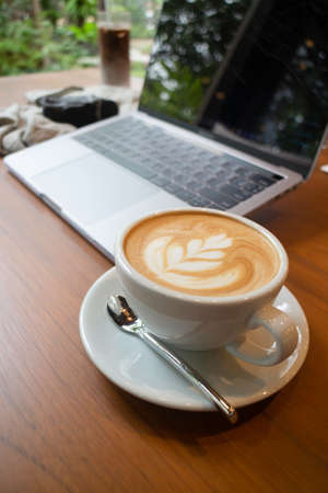 Cup of coffee and laptop on the table, stock photoの写真素材