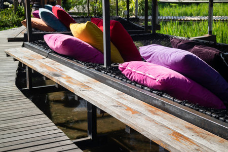 Colorful pillows on net seat among nature, stock photoの写真素材