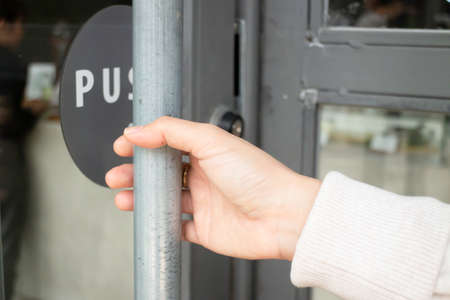 Hand on handle door for open to entering restaurant, stock photoの写真素材