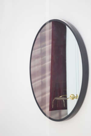 Black framed mirror on a white wall, stock photoの写真素材
