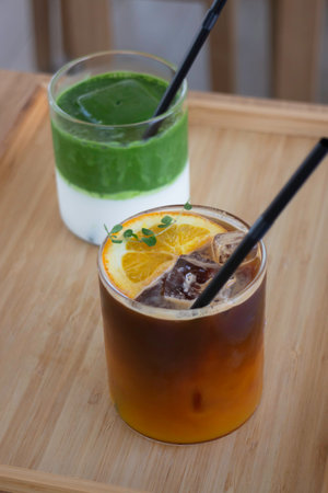 Iced matcha greentea and iced black orange coffee on wooden table, stock photoの写真素材