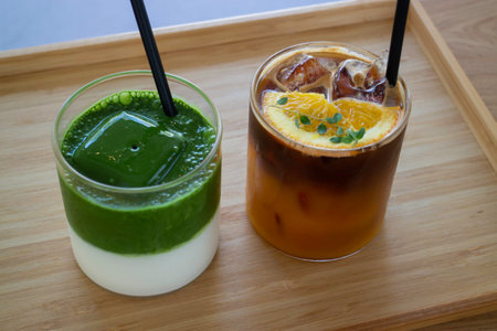 Iced matcha greentea and iced black orange coffee on wooden table, stock photo