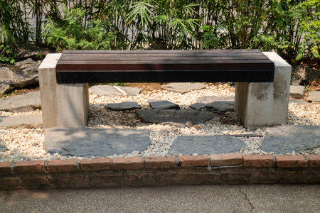 wooden bench in the garden with pebbles and stones.