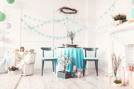 Beautiful Easter basket full of eggs on blue festive table in decorated room