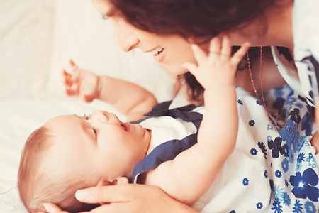 Beautiful little baby girl lies on a light carpet with mom. happy mother with baby