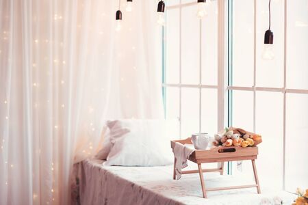 Beautifully decorated tray with a bouquet of tulips and a Cup of teaの写真素材