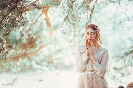 Beautiful artistic photo portrait of a mysterious girl in white dress in the woodsの写真素材