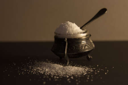 salt in the straw with a spoon. black background