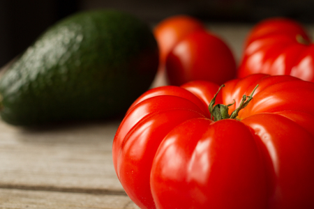 tomato with avocado and garlic with dill. on wood backgroundの写真素材