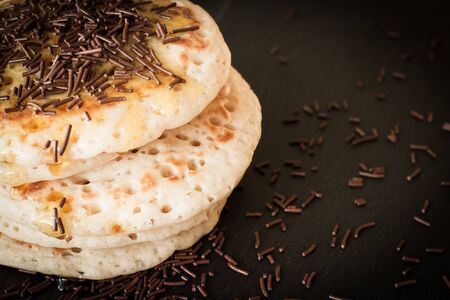 pancakes with honey and maple syrup with chocolate sprinklesの写真素材