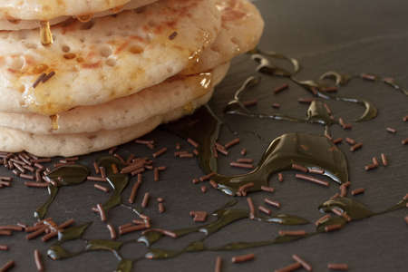 pancakes with honey and maple syrup with chocolate sprinklesの写真素材