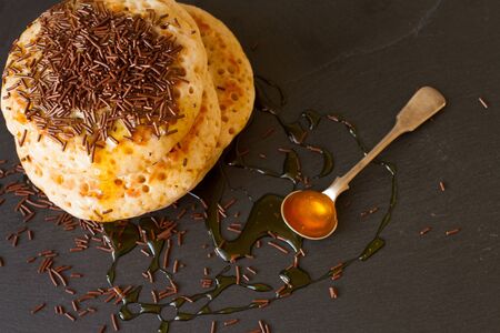 pancakes with honey and maple syrup with chocolate sprinklesの写真素材