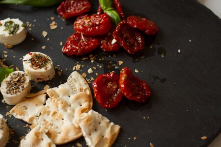 crackers with goat cheese, sun-dried tomatoes and basilの写真素材