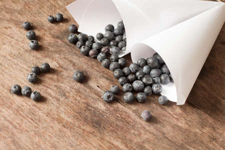Blueberries in white bags of paper on a wooden backgroundの写真素材