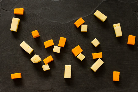 yellow and white cheddar cheese on a black backgroundの写真素材