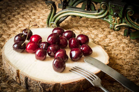 cherries with green kitchen scales and cut wood