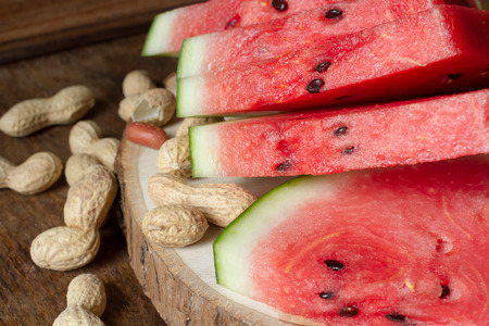 ripe red watermelon with peanuts on wooden backgroundの写真素材