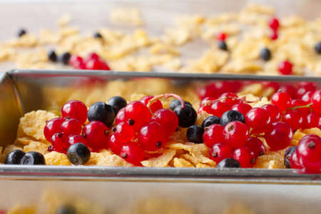 corn flakes with red currants and blueberries for breakfastの写真素材