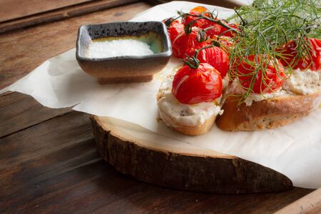 baked tomatoes with bread and dill on a wooden tableの写真素材