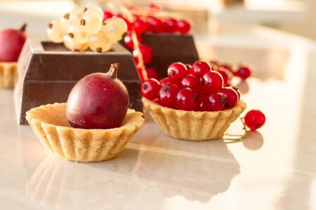 red and white currant with chocolate on marbleの写真素材