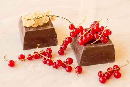 red and white currant with chocolate on marbleの写真素材