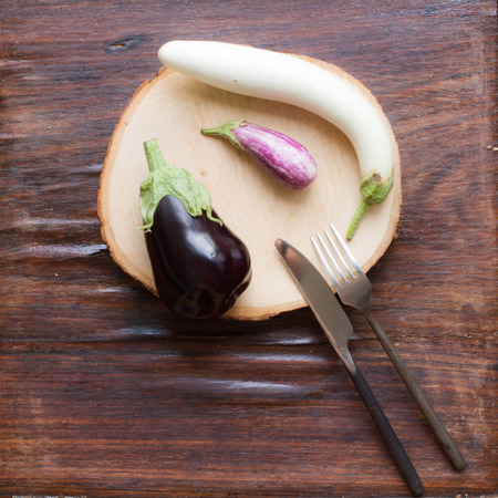small eggplants on a wooden cutting boardの写真素材