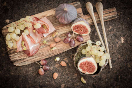 snacks for wine grapes in the form of dates and baconの写真素材