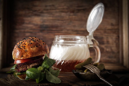 homemade veggie burger in a bun with sesame seeds of beer. delicious fast food for vegans. on a wooden backgroundの写真素材