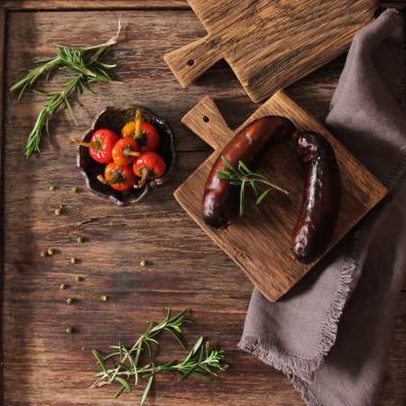 bratwurst grill with salt and pepper and rosemary on brown wooden backgroundの写真素材