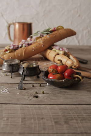 Hot dog with sausage and beer and red hot pepper on a brown background propkiの写真素材