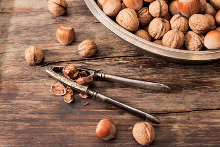 mixture of nuts on a metal plate with orehokolom on a wooden background