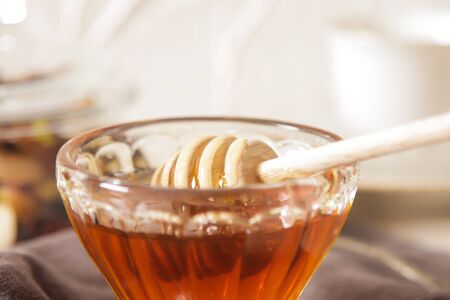 Fresh delicious honey in a crystal glass on a light backgroundの写真素材