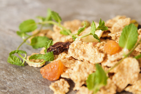 muesli with nuts and dried fruits mint leaf on a gray stone background