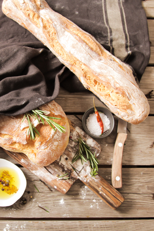 Sliced bread Ciabatta and rosemary on wooden backgroundの写真素材
